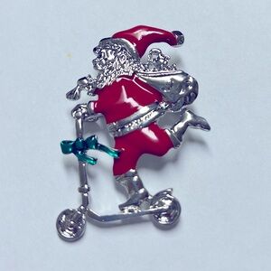 Brooch- Santa on scooter,NIP, silver w/ red enamel paint, 1.75x1.5”